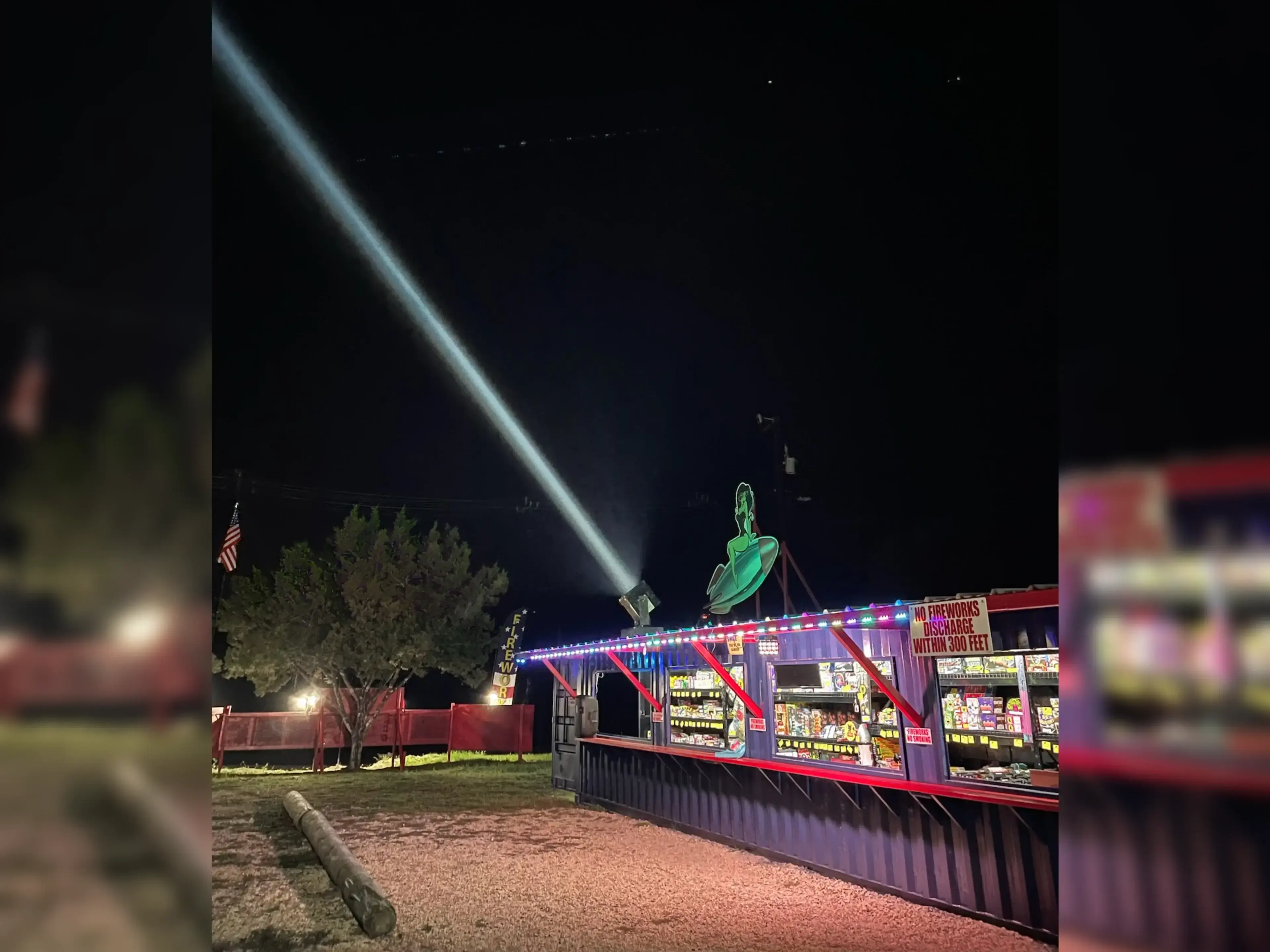 Firework stand illuminated at night.